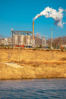 A friendly engineer discussing plans with a client beside industrial pollution control equipment.