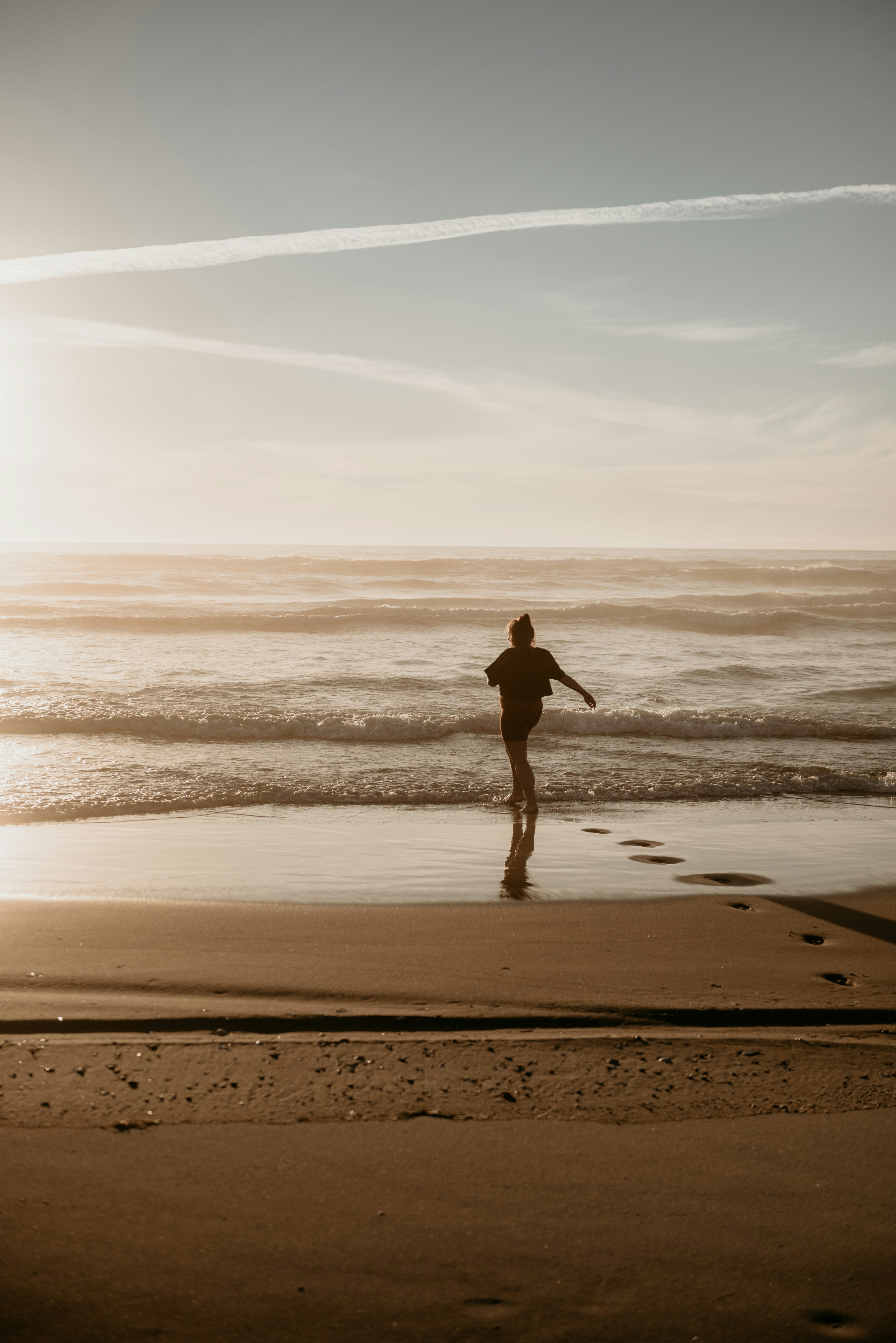 a person walking on a beach near the ocean