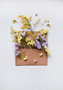 Close-up of colorful flower petals spilling out of a red post box with traditional Indian motifs