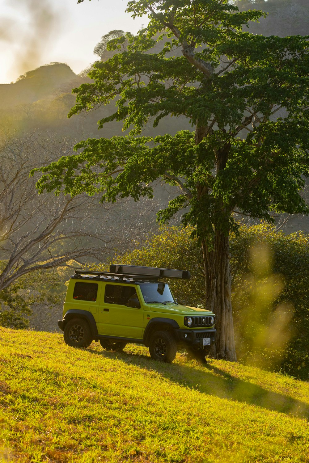 a yellow jeep is parked on the side of a hill