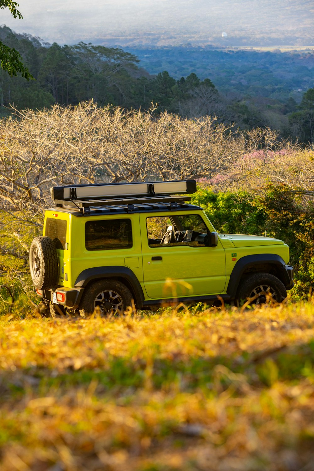 a bright yellow jeep is parked in a field