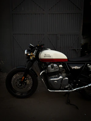 Custom dual-color owl fog lights glowing on a Royal Enfield parked near industrial garage walls.