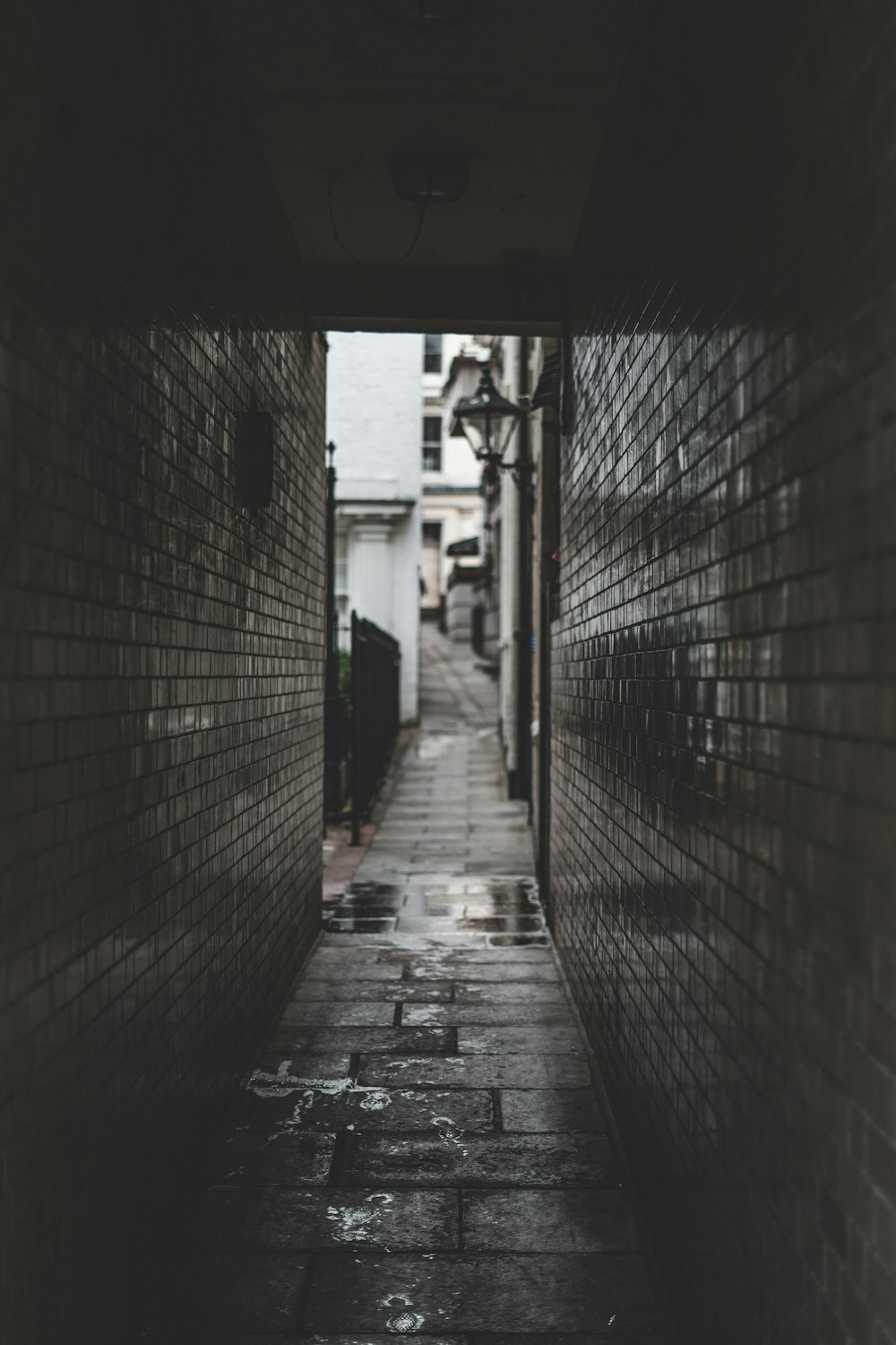 a narrow alley way with a brick wall