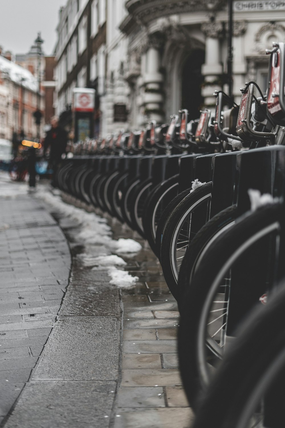 a row of bikes parked next to each other on a sidewalk