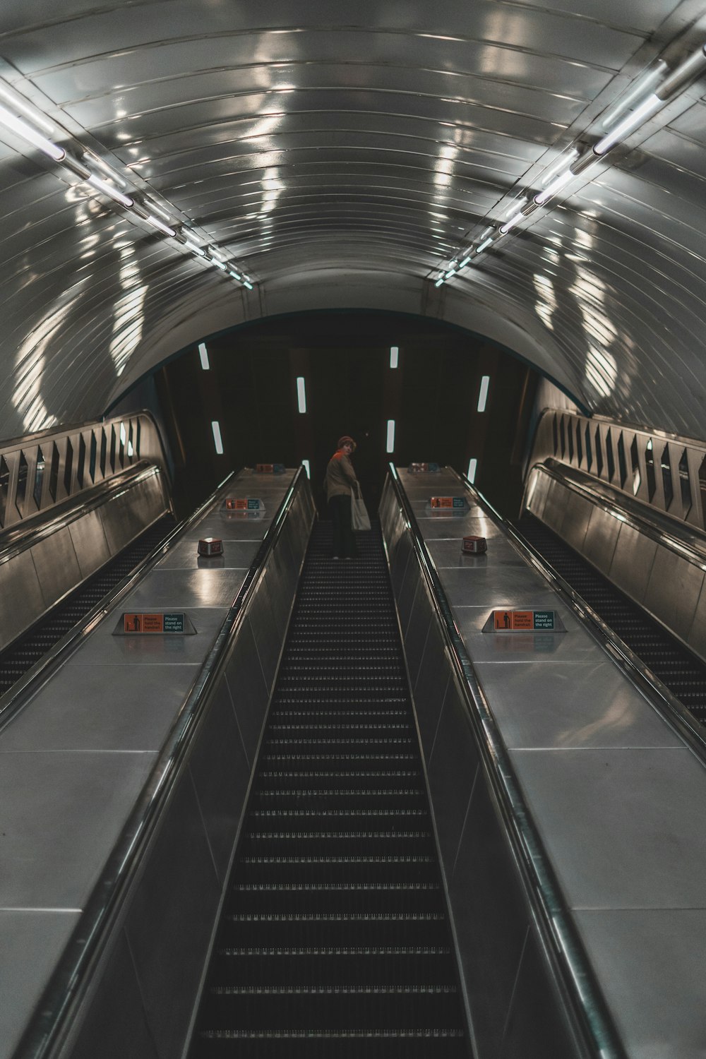 an escalator in a subway station with people on the escalators