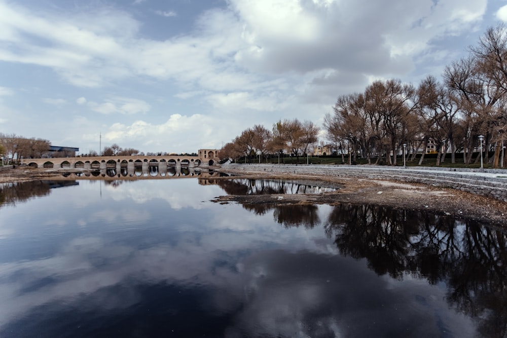 a large body of water with a bridge in the background