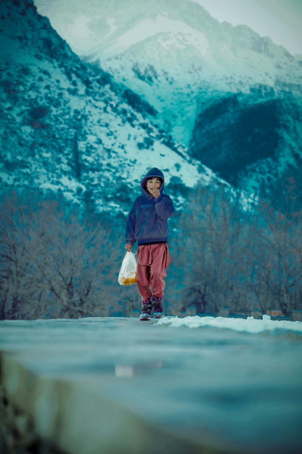 a man standing in the snow with a bag