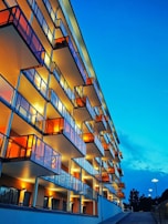Finished luxury apartment building with clean lines and warm lighting at dusk.