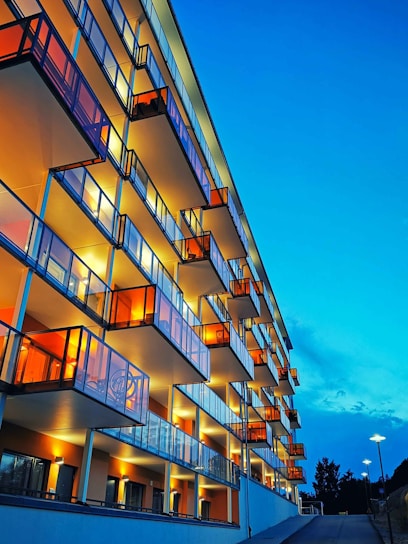 A modern apartment building with clean lines and warm lighting at dusk.