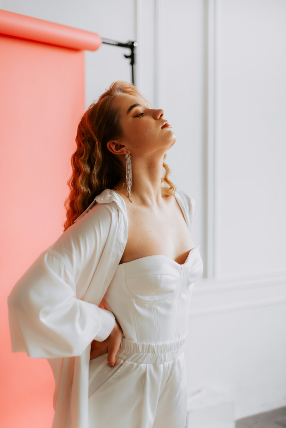 a woman in a white dress looking up