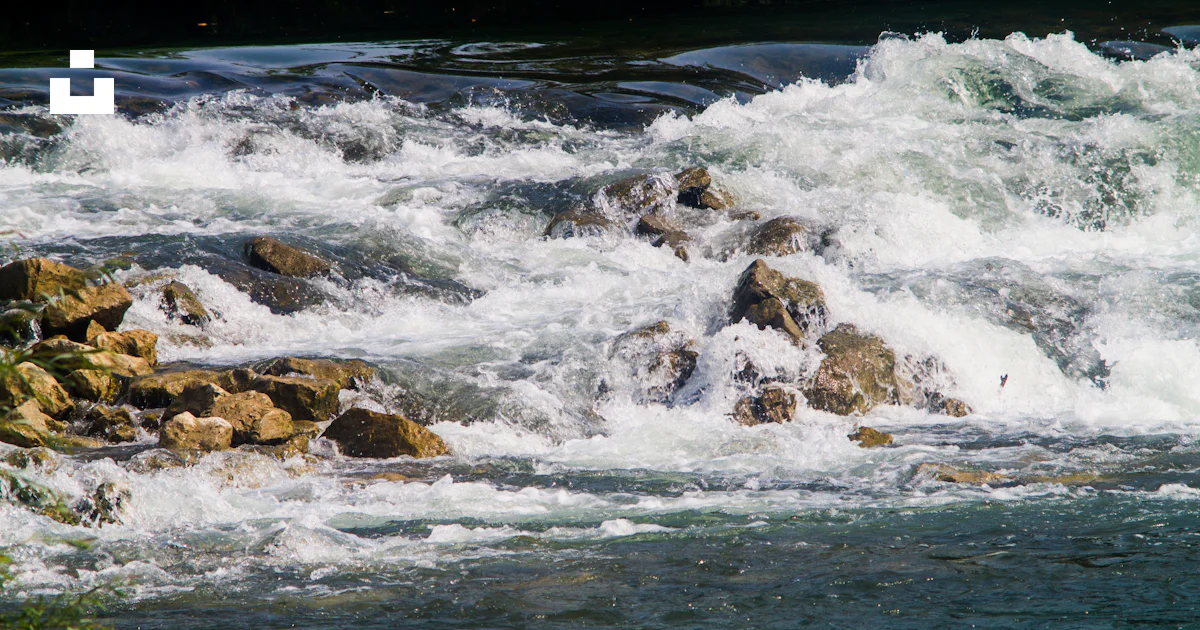 The water is rushing over the rocks in the river photo – Free Water ...
