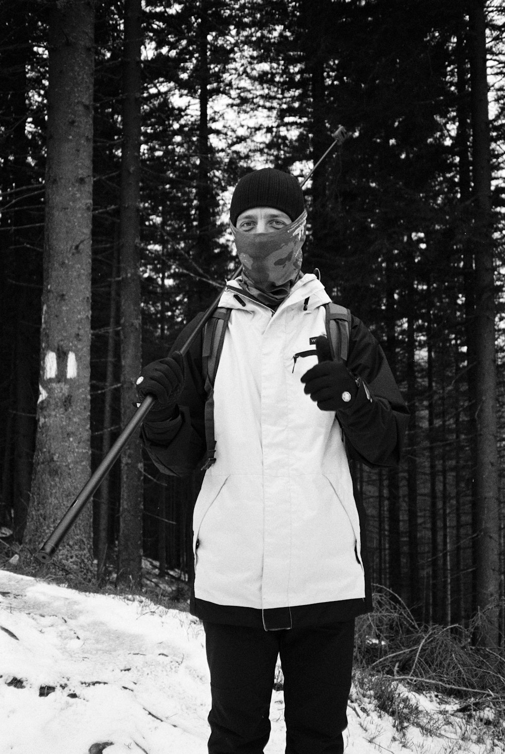 a man standing in the snow holding ski poles