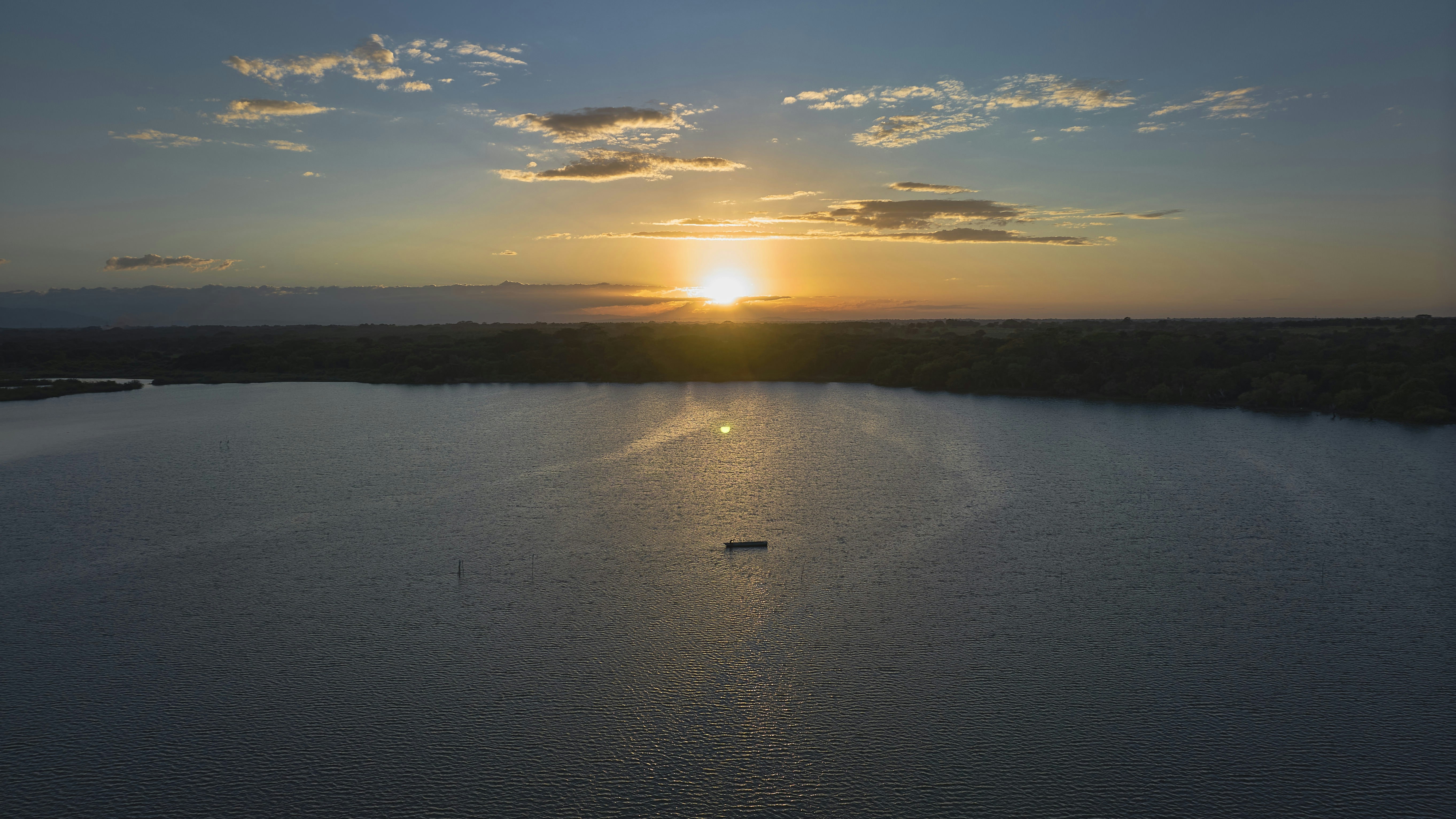 the sun is setting over a large body of water