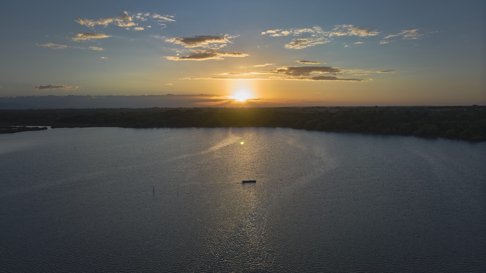 the sun is setting over a large body of water