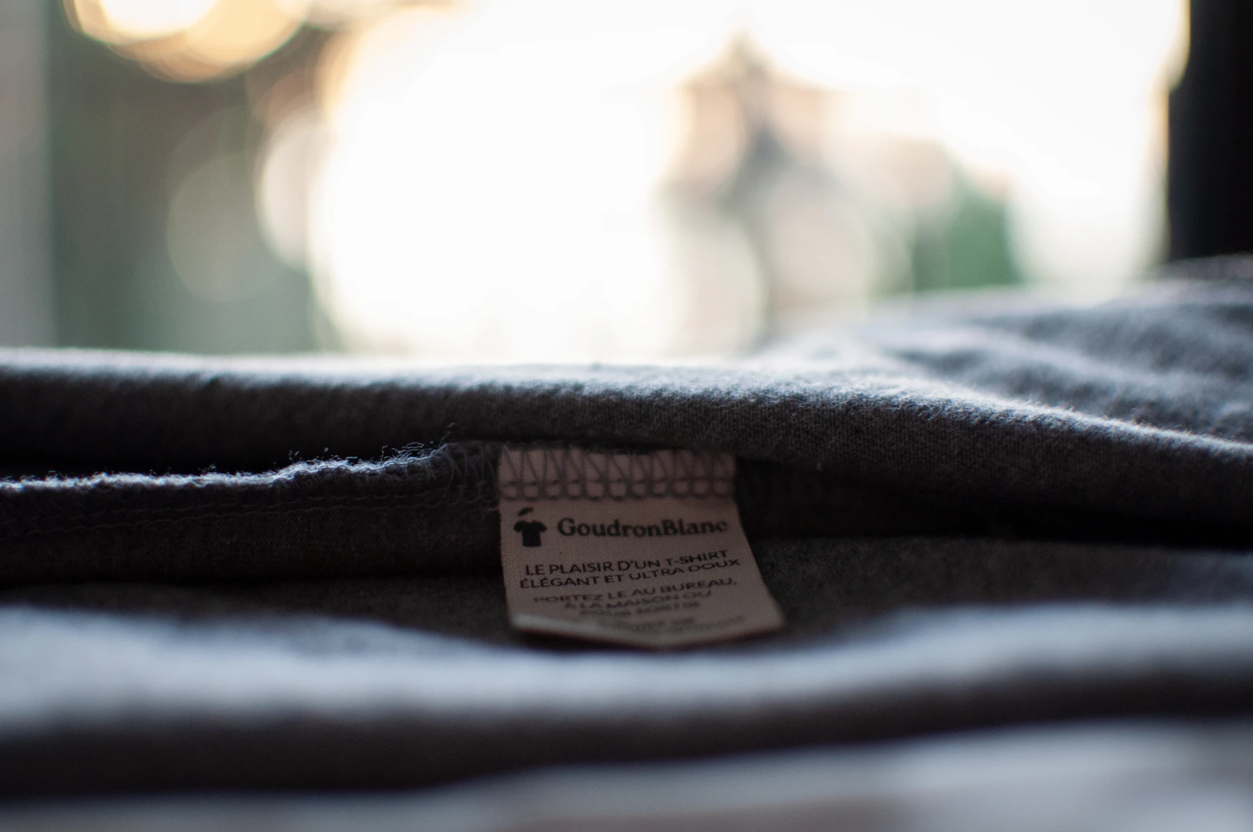 Close-up of a garment composition label stitched into a dark shirt