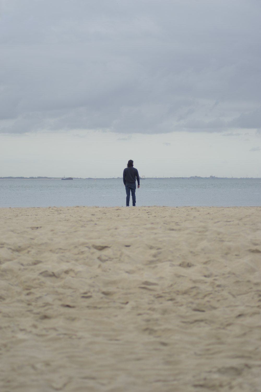 a man standing on top of a sandy beach