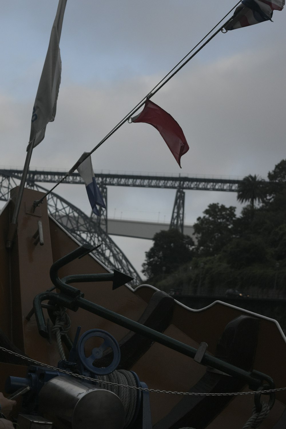 a boat with two flags on it and a bridge in the background
