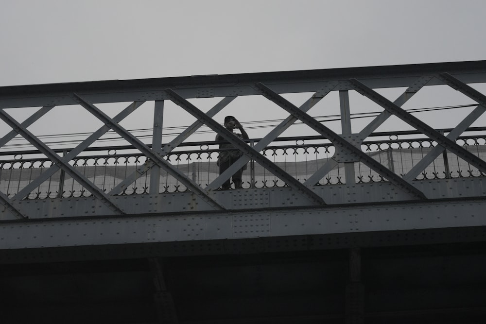 a person walking across a bridge over water