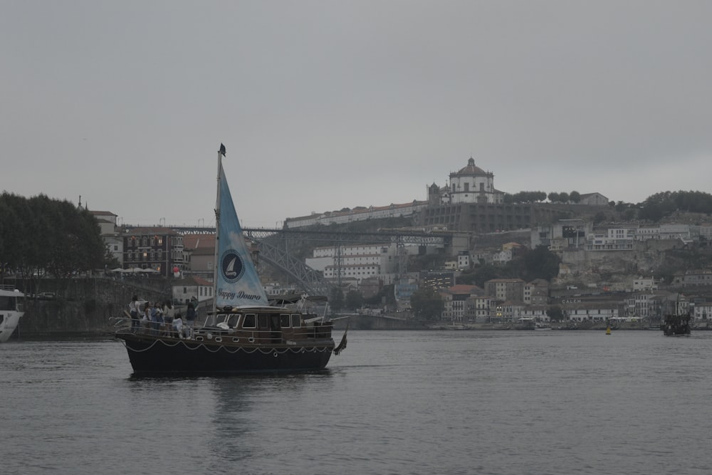 a boat with a blue sail on a body of water