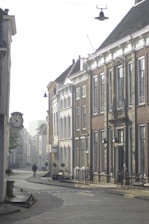 A quiet cobblestone street in a European village bathed in soft morning light.