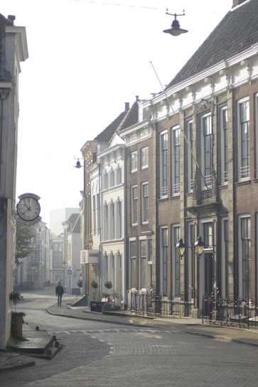 A serene cobblestone street bathed in soft morning light, framed by historic European architecture.