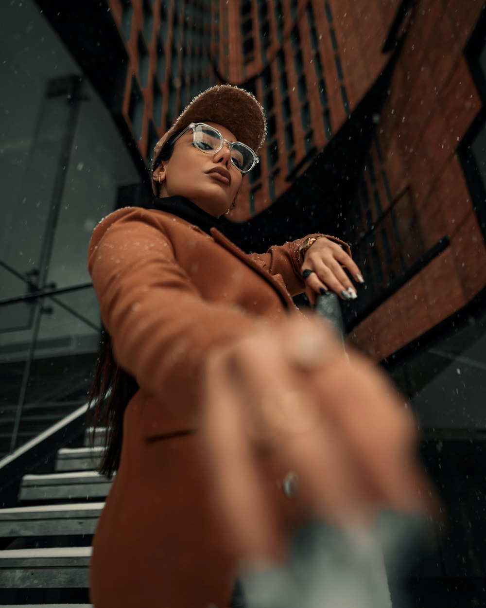 a woman in a brown coat and hat holding a cell phone