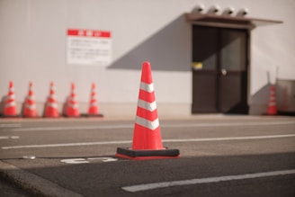 Industrial safety signs and traffic cones arranged in a warehouse setting.