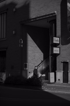 Black and white photo of a quiet urban alley with dramatic shadows.