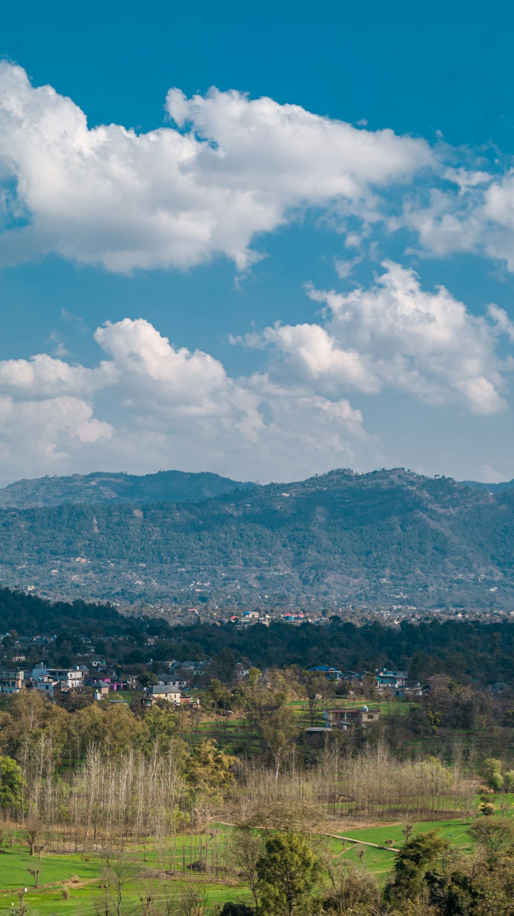 a scenic view of a town and mountains in the distance