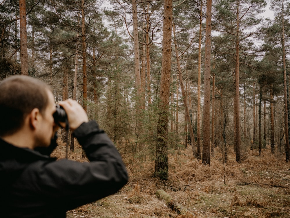 a man taking a picture of a forest