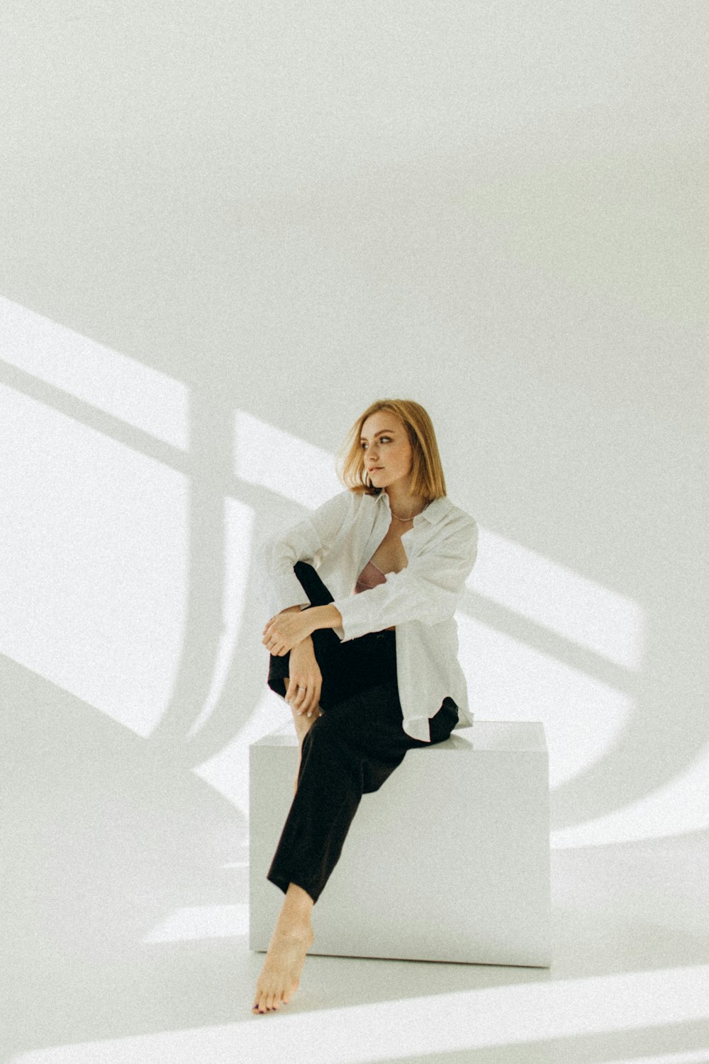 a woman sitting on top of a white box