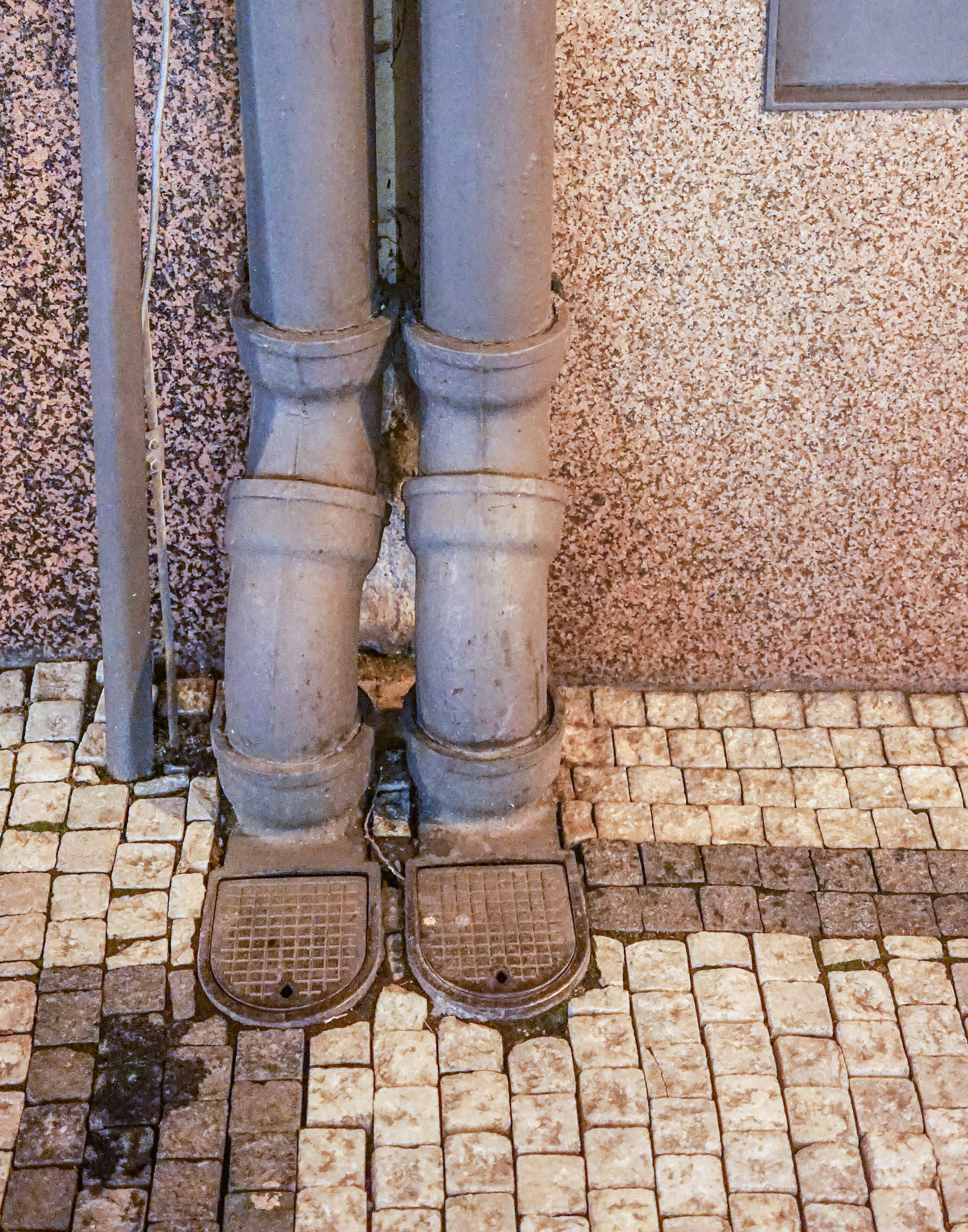 a close up of a pair of metal pipes on a tiled floor