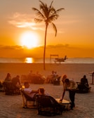 Executives sharing a relaxed moment on a tropical beach at sunset