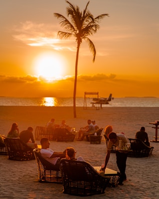 Executives sharing a relaxed moment on a tropical beach at sunset