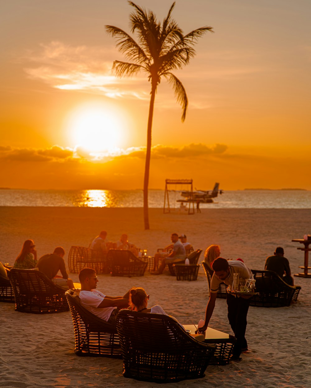 a group of people sitting on top of a sandy beach