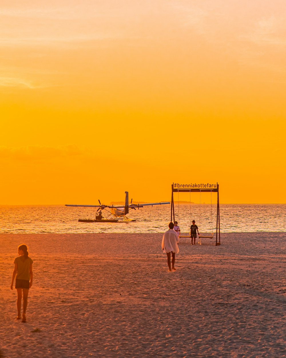 a group of people standing on top of a sandy beach