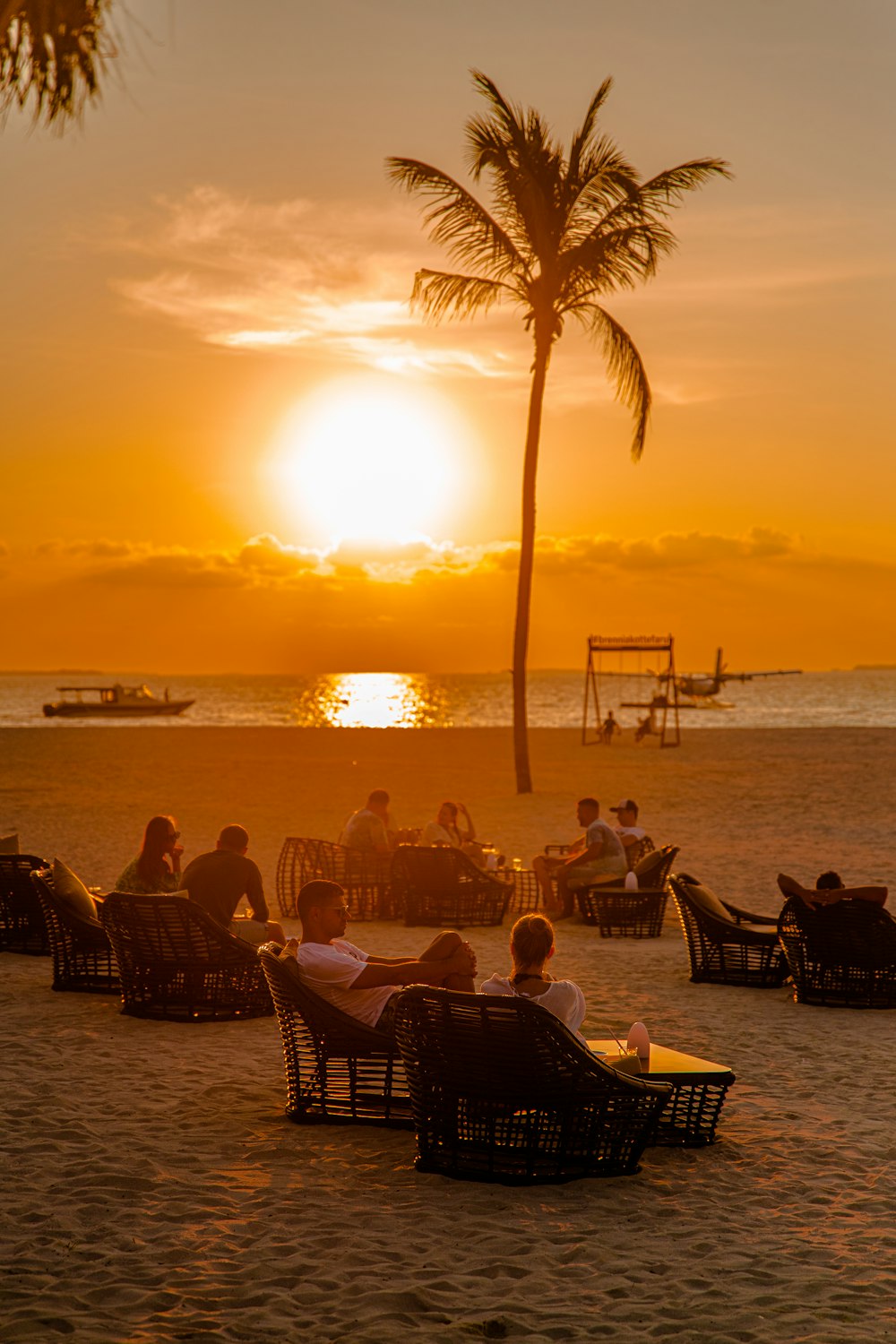 a group of people sitting on top of a sandy beach