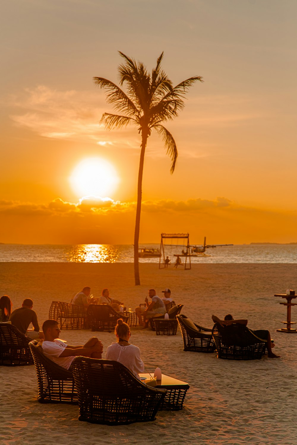 a group of people sitting on top of a sandy beach