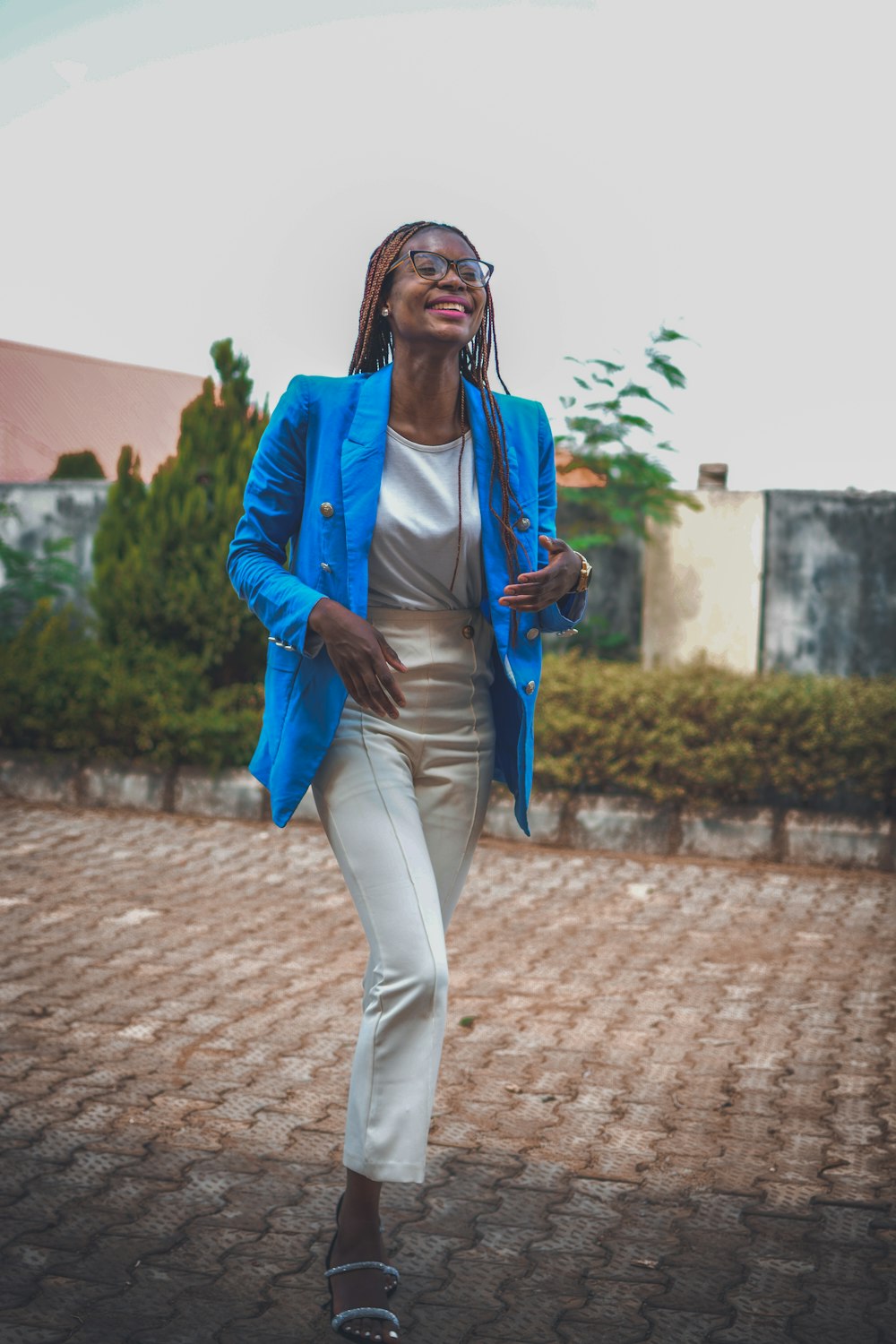 a woman wearing a blue jacket and white pants