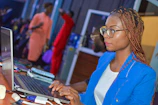 a woman sitting in front of a laptop computer