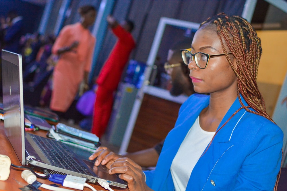 a woman sitting in front of a laptop computer