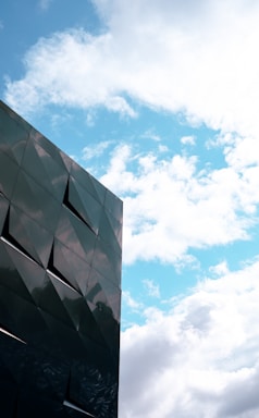A sleek, modern porta cabin office with a dark blue and gold trim under a bright sky.