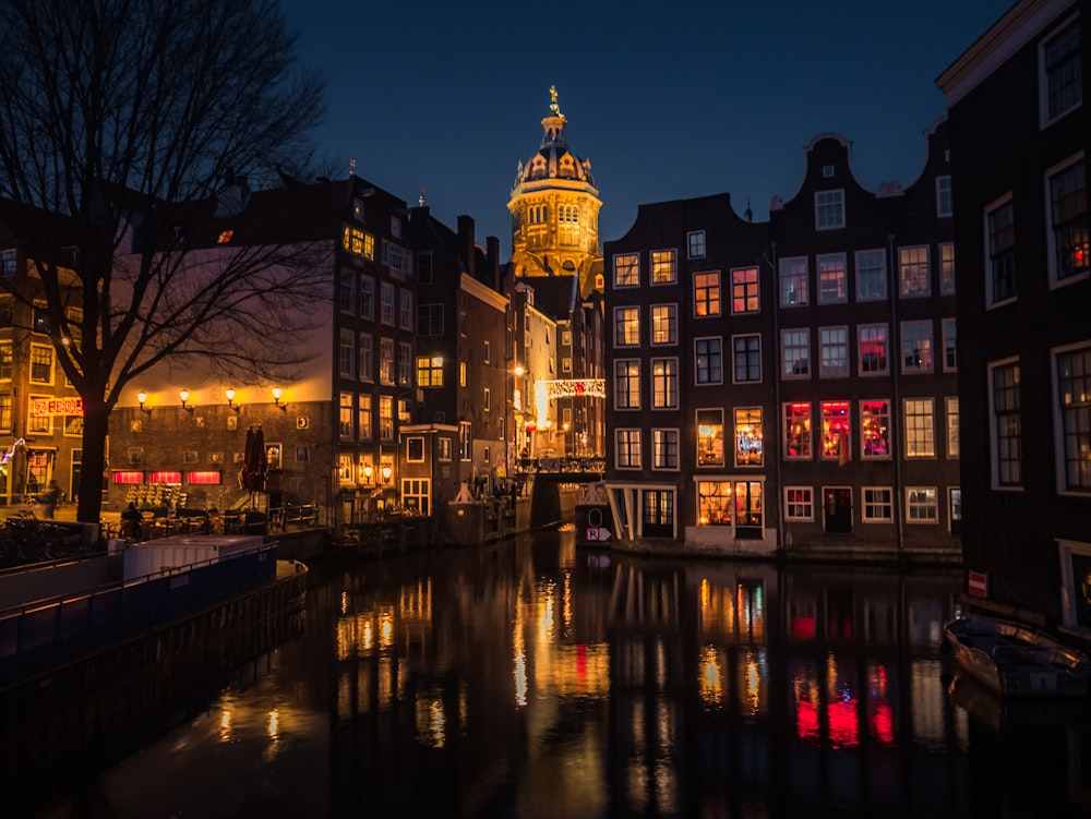 a city with a river and buildings lit up at night