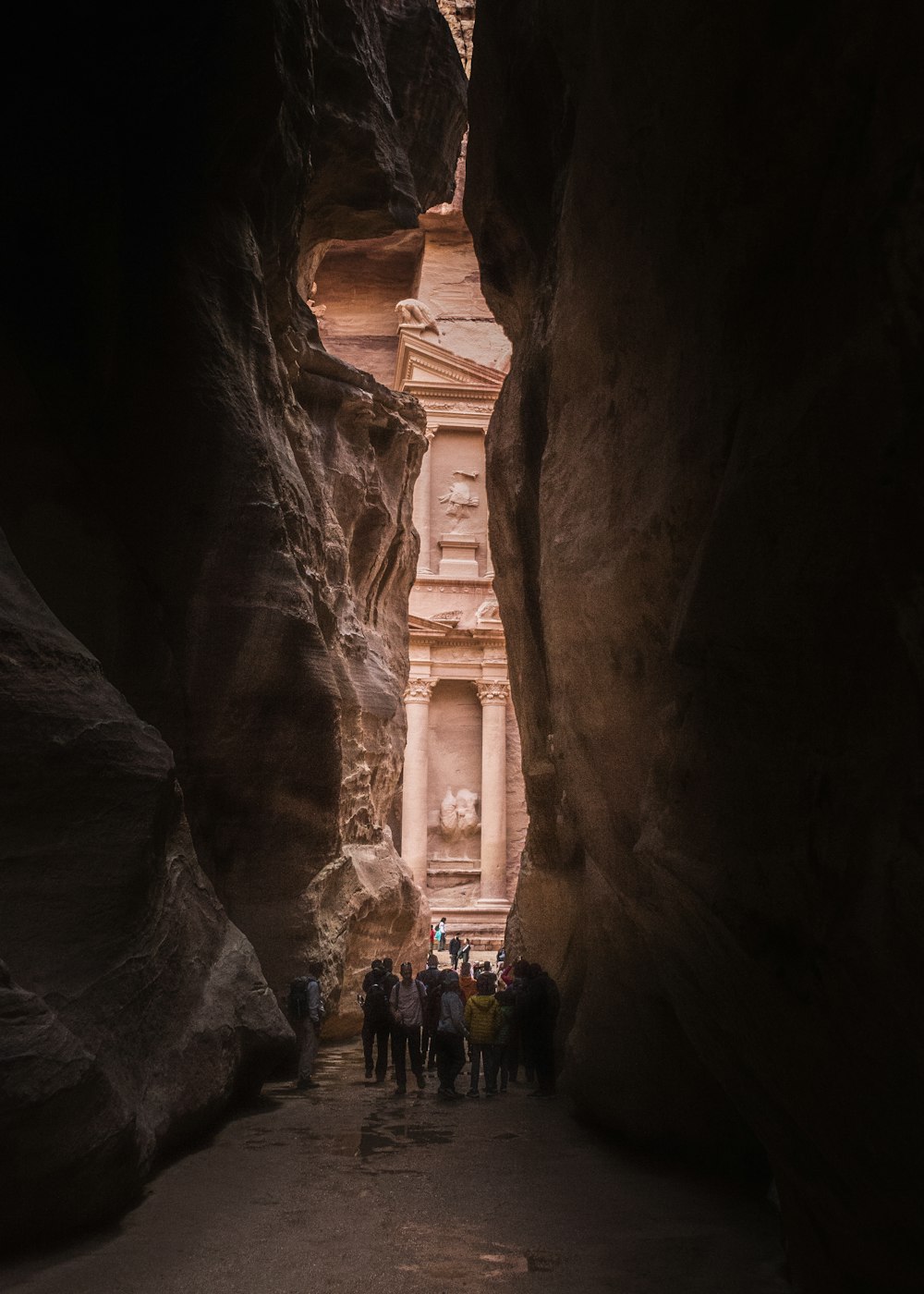 a group of people standing in a narrow canyon