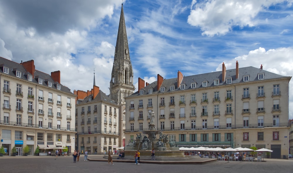 a large building with a tower and a fountain in front of it