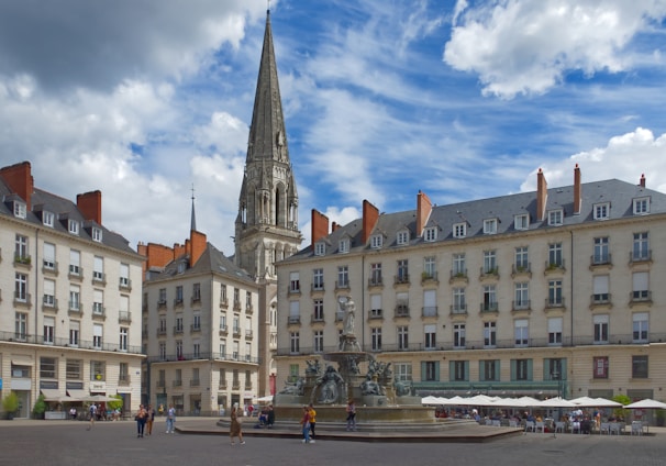 a large building with a tower and a fountain in front of it