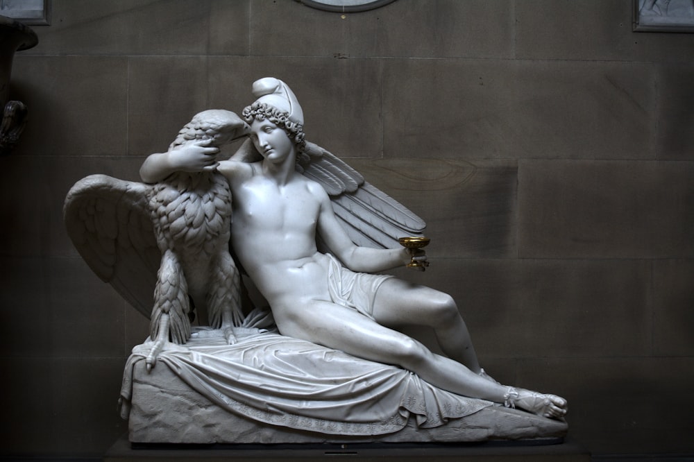 une statue d’un homme et d’une femme tenant un oiseau