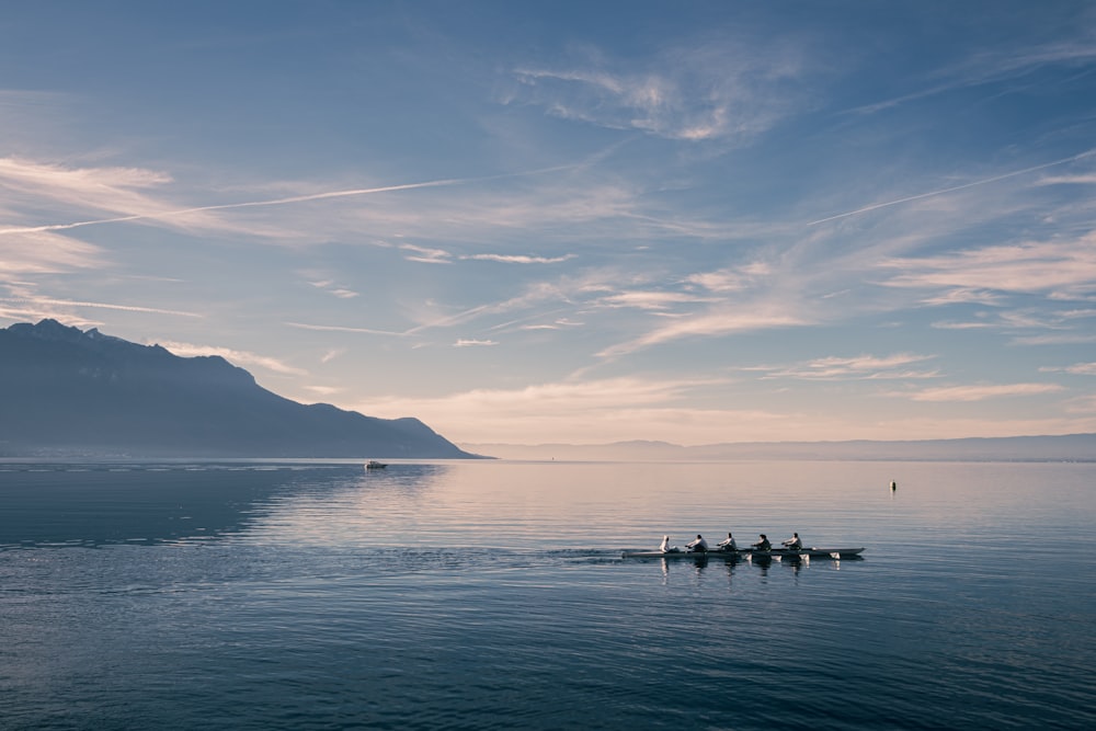 a group of people rowing a boat in the water