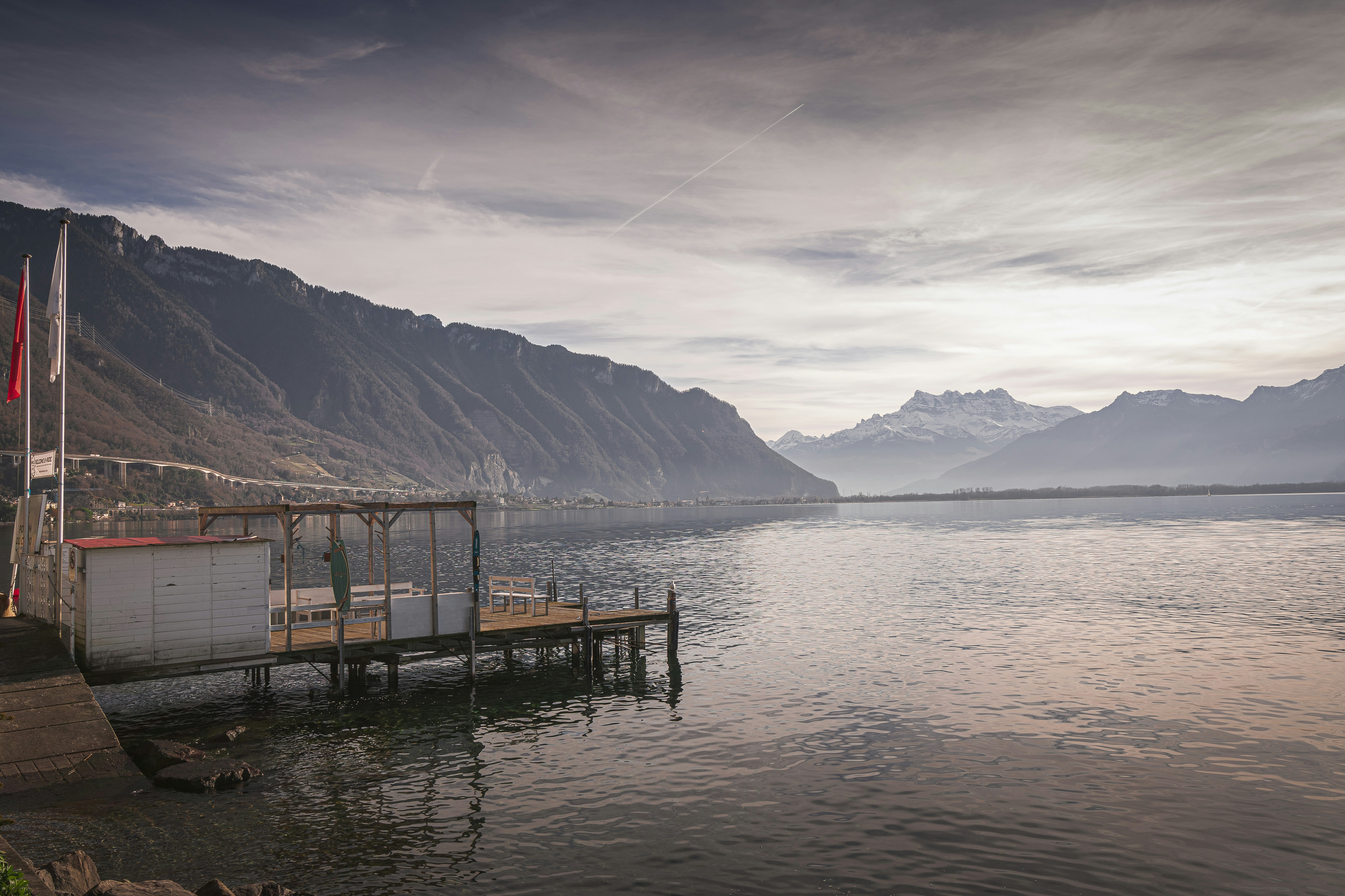 a boat dock on a lake with mountains in the background