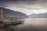 a boat dock on a lake with mountains in the background